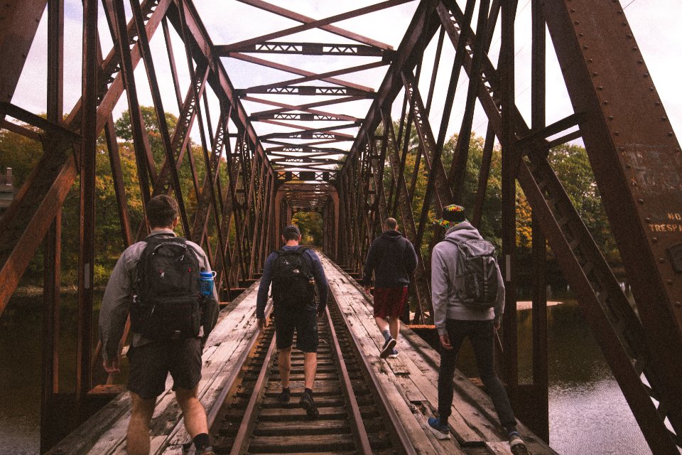 Illustrative image: people walking across a rail bridge